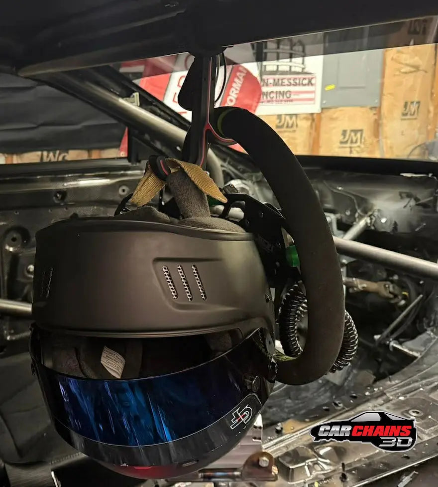 Race helmet and steering wheel secured on Car Chains 3D dual hook roll cage holder in performance race car cockpit